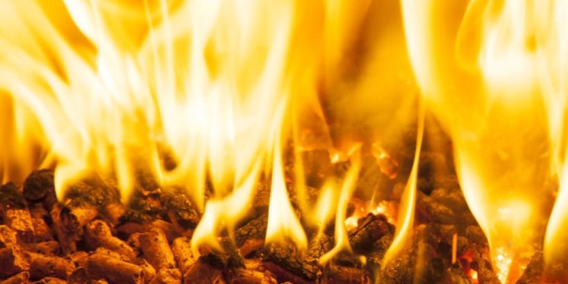 Closeup of burning wood pellets in oven.